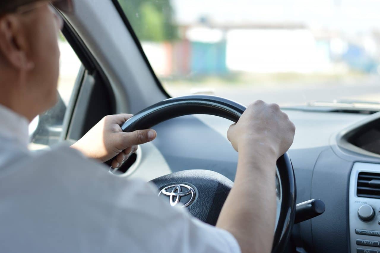 Close up of man's hands while driving.