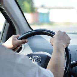 Close up of man's hands while driving.